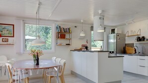 A modern kitchen with white cabinetry, a central island, and pendant lighting.