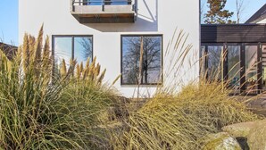 Un edificio moderno de dos pisos con amplios ventanales y un balcón.