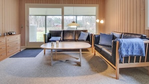 A cozy living room with a sofa, a coffee table, and a lamp.