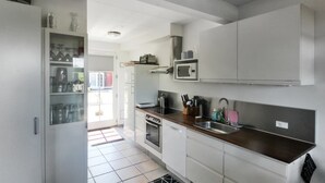 A modern kitchen with white cabinets, a stainless steel sink, and a microwave. - "Karoline" - 6km from the sea by Interhome (Aakirkeby)