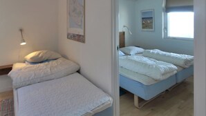 A bedroom with two beds, a map on the wall, and a window with a view. - "Thorke" - 5km from the sea by Interhome (Aakirkeby)