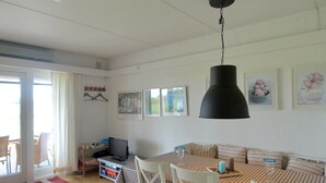A cozy living room with a checkered table, white chairs, a television, and artwork on the walls. - "Thorke" - 5km from the sea by Interhome (Aakirkeby)