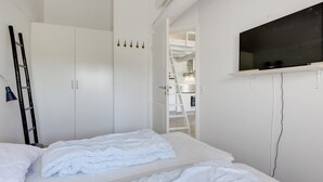 A bedroom with a bed, a wardrobe, a TV mounted on the wall, and a ladder leaning against the wall. - "Antine" - 6km from the sea by Interhome (Aakirkeby)