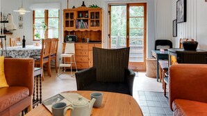 Un salon chaleureux avec une table basse en bois, un fauteuil en osier et un canapé en cuir.