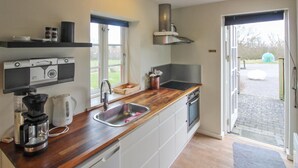 A modern kitchen with a wooden countertop, stainless steel sink, and built-in appliances. - "Lutz" - 6km from the sea by Interhome (Aakirkeby)