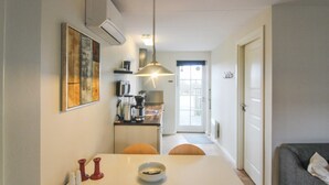 A compact kitchen with a dining table, chairs, a coffee machine, and a hanging light fixture. - "Lutz" - 6km from the sea by Interhome (Aakirkeby)