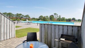 Ein Garten mit Swimmingpool, Grill und Gartenmöbeln.