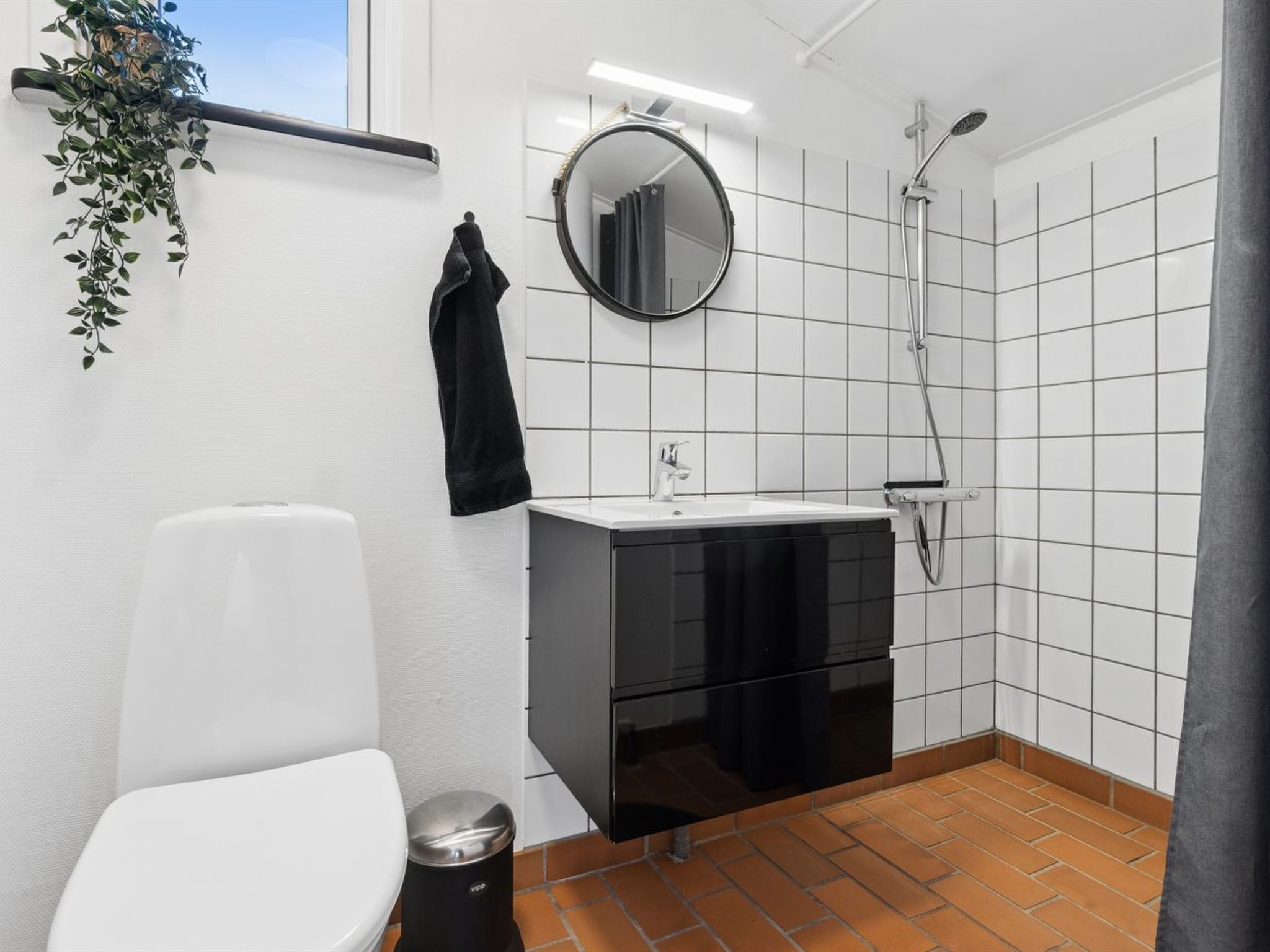 Une salle de bain équipée de toilettes, d’un lavabo, d’un miroir et d’une douche.