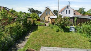 Ein Wohngebiet mit Häusern, einem Gartenweg und einer Holzterrasse.