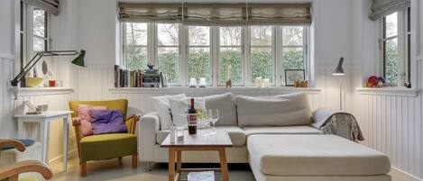 A bright living room with a sofa, armchair, and a coffee table.