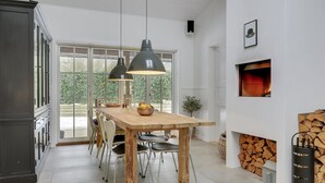 A modern kitchen with a wooden table, pendant lights, and a fireplace. - "Emely" - 700m from the sea by Interhome (Jægerspris)