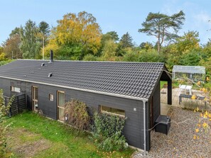 A modern building with a dark exterior, a sloped roof, and a small attached greenhouse. - "Aino" - 1km from the sea by Interhome (Liseleje)