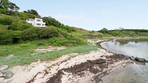 A coastal property with a two-story house, a sandy beach, and a calm sea. - "Grumme" - 30m to the fjord by Interhome (Ølsted)