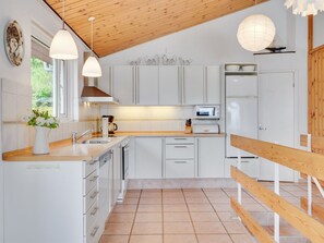 Een koelkast, een magnetron, een vaatwasser, kookgerei, borden en bestek