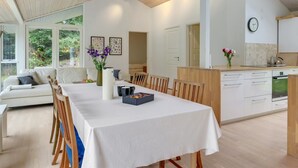 Une cuisine moderne avec des armoires blanches, un plan de travail en bois et une horloge au mur.