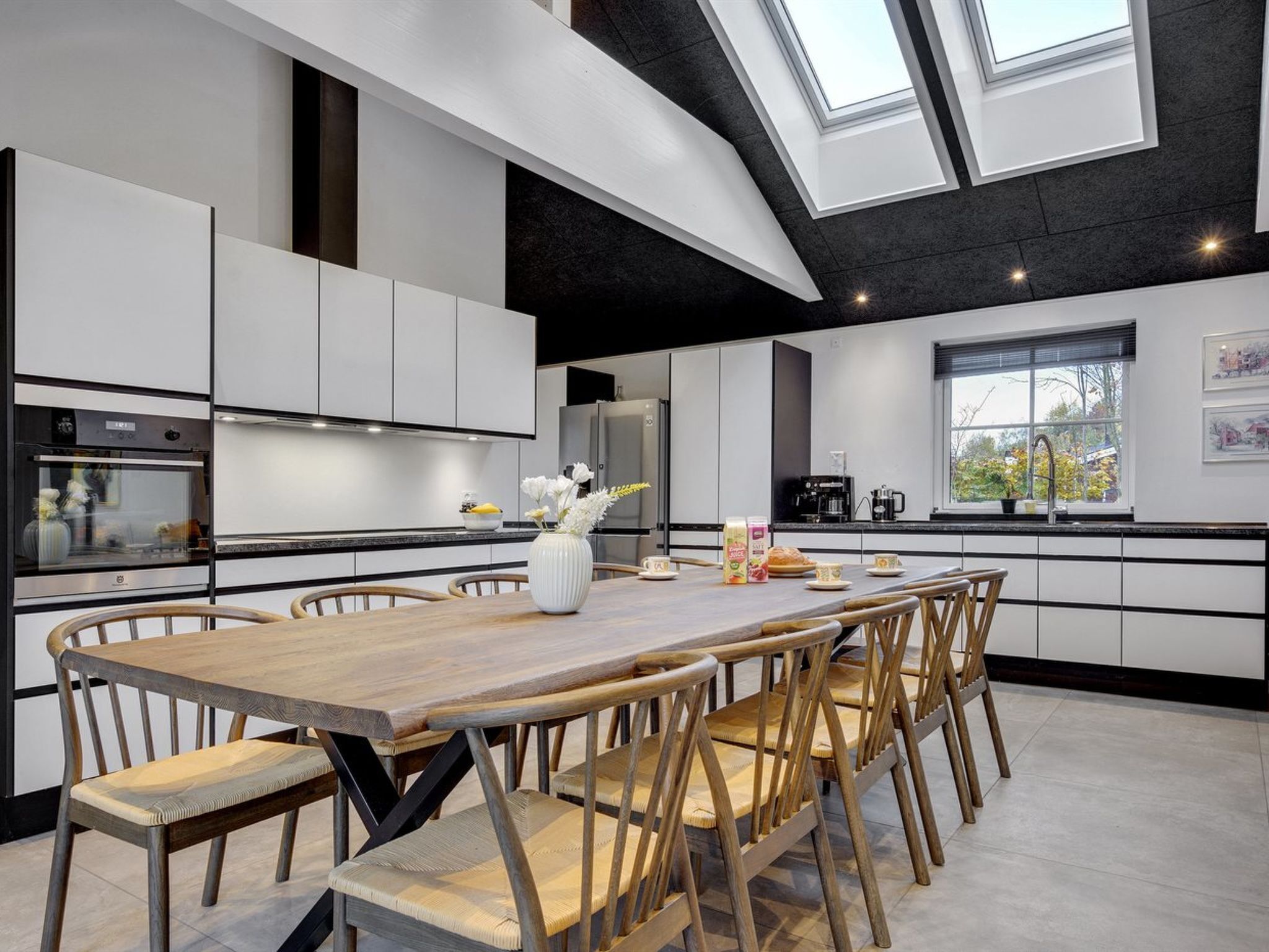 Een moderne keuken met een centraal eiland, inbouwapparatuur en een dakraam.