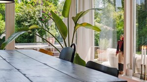 A dining area with a wooden table, chairs, and a large plant. - "Gritt" - 800m from the sea by Interhome (Gilleleje)