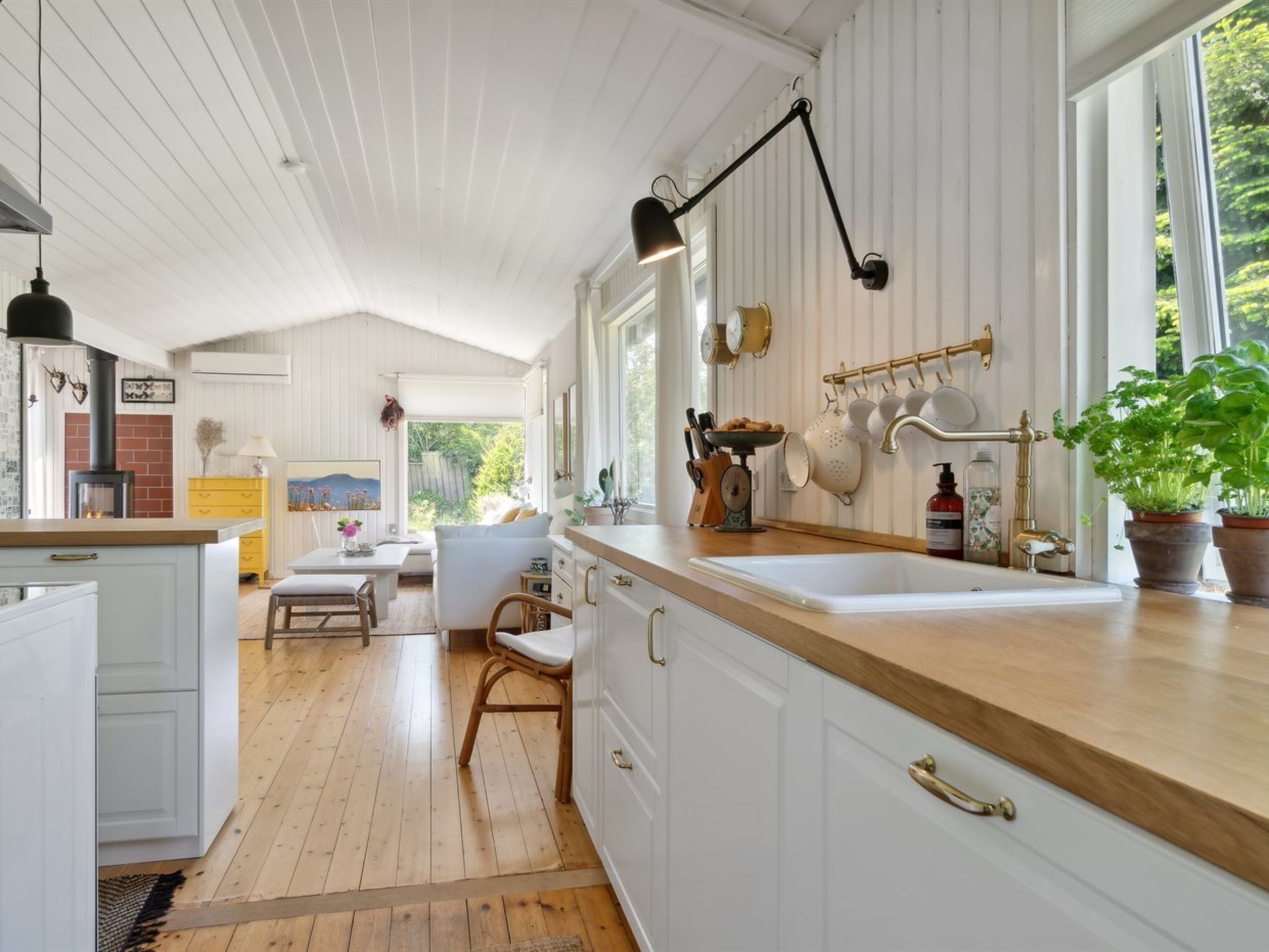 A spacious kitchen with white cabinetry, a wooden countertop, and a large window providing natural light.