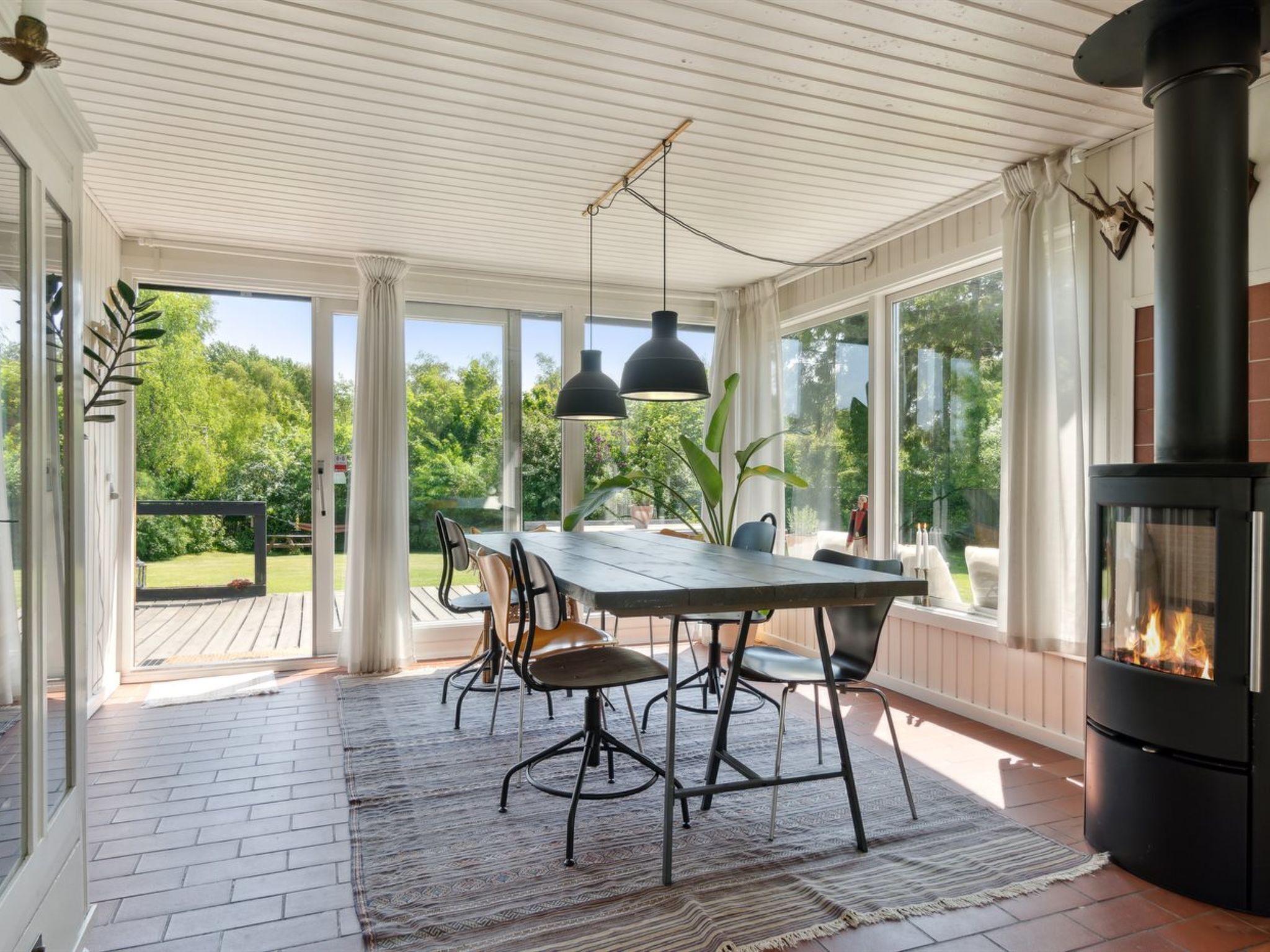 Une terrasse couverte avec une table à manger, des chaises et une cheminée.