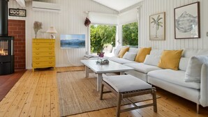 A cozy living room with a fireplace, a sofa, a coffee table, and a yellow dresser. - "Gritt" - 800m from the sea by Interhome (Gilleleje)