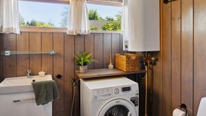 A compact bathroom with a washing machine, a sink, and a window with curtains. - "Sjard" - 700m from the sea by Interhome (Gilleleje)