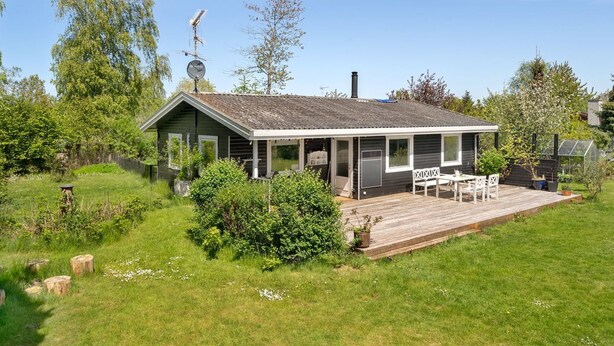 A single-story house with a covered porch, a satellite dish, and a chimney.