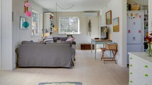 A cozy room with a bed, a desk, and a dining area.