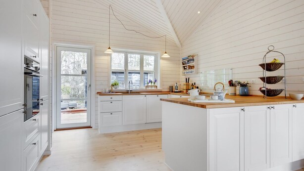A spacious kitchen with white cabinetry, a wooden island, and a large window providing natural light. - "Anar" - 900m from the sea by Interhome (Græsted)