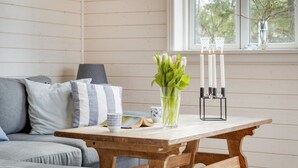 A cozy room with a wooden table, a vase of flowers, and a candle holder. - "Anar" - 900m from the sea by Interhome (Græsted)