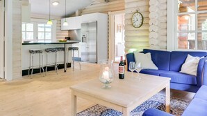 Indretning i en hyggelig hytte med køkken, spiseplads og opholdstue.