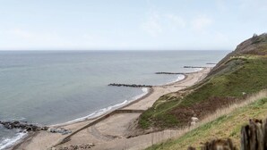 A coastal landscape with a sandy beach, rocky outcrops, and grassy terrain. - "Tabetha" - 25m from the sea by Interhome (Tisvildeleje)