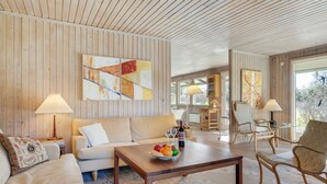 A spacious living room with a wooden ceiling, a sofa, a coffee table with fruits, and a view to the outside. - "Naira" - 1.8km from the sea by Interhome (Tisvildeleje)