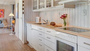 A modern kitchen with white cabinetry, a built-in oven, and a wooden countertop. - "Naira" - 1.8km from the sea by Interhome (Tisvildeleje)
