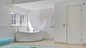 A modern bathroom with a large bathtub, a shower, and a separate pool area. - "Drude" - 920m from the sea by Interhome (Vejby)