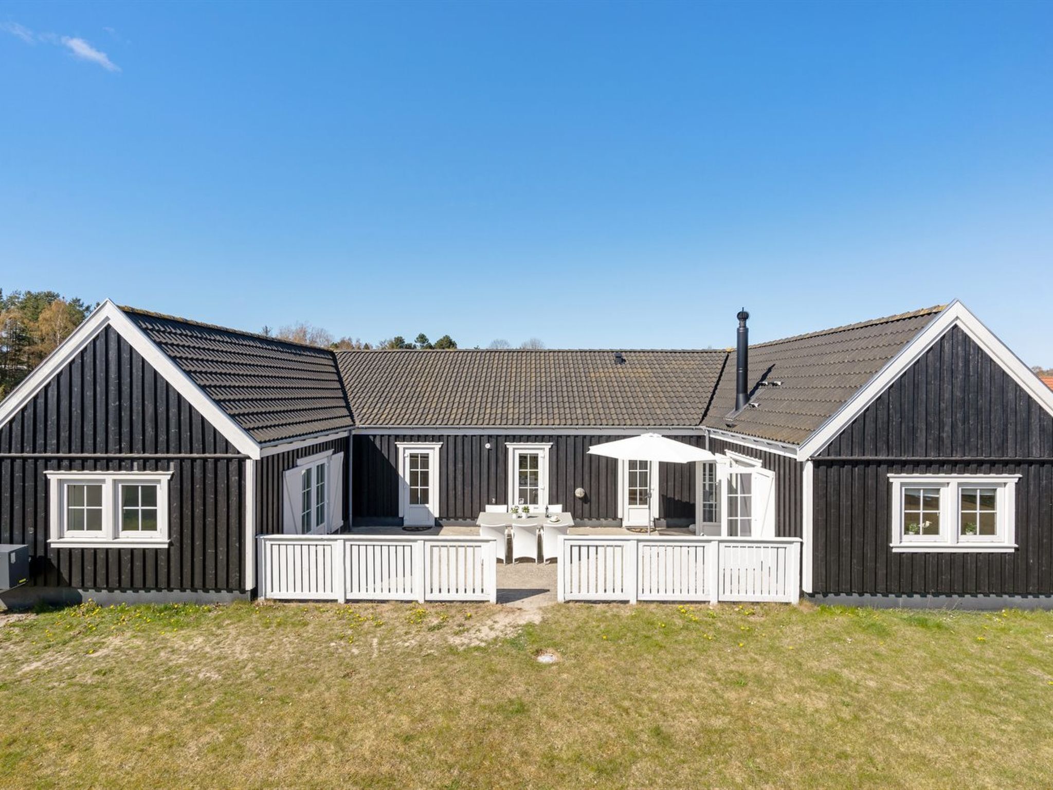 A two-story house with a front porch and a covered patio area.