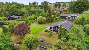 A residential area with multiple houses surrounded by lush greenery and trees.