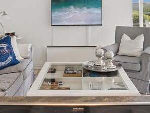 A modern living room with a large wall-mounted TV, striped sofas, a coffee table with decorative items, and a bookshelf. - "Ylermi" - 1.5km from the sea by Interhome (Dronningmølle)