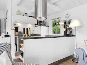 Una cocina moderna con una isla central, electrodomésticos integrados y un amplio ventanal que proporciona luz natural.