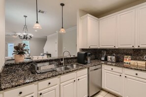 Enjoy cooking in this well-equipped kitchen with a double sink, coffee maker, and toaster.