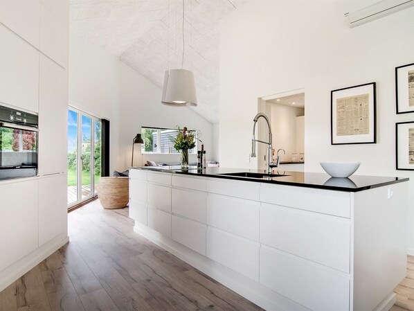 Kjøleskap, ovn, oppvaskmaskin og høy barnestol