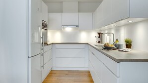 A modern kitchen with white cabinetry, a wooden countertop, and a built-in oven. - "Pekka" - 50m from the sea by Interhome (Helsingør)
