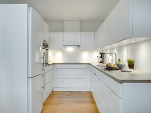 Kjøleskap, ovn, oppvaskmaskin og høy barnestol