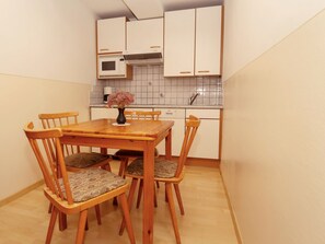 Cozy kitchen area with a dining table and chairs, microwave, and range hood.