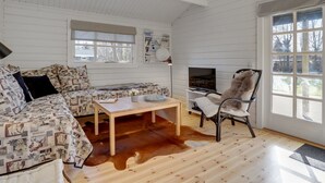 A cozy living room with a patterned sofa, a coffee table, a TV, and a chair. - "Freyja" - 800m from the sea by Interhome (Væggerløse)