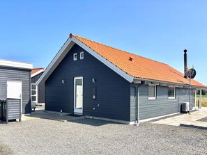 Ein zweistöckiges Gebäude mit einem geneigten Dach, einer Haustür und einem kleinen Fenster.