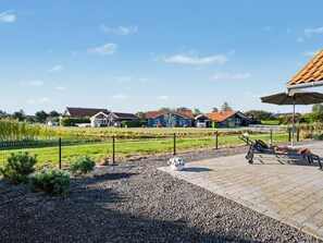 Ein Wohngebiet mit Häusern, einer gepflegten Schotterterrasse und einem umzäunten Garten.