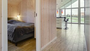 Une chambre à coucher moderne avec un plancher en bois, un lit et une table de chevet.