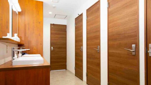 A modern bathroom with a wooden vanity, a sink, and a mirror. - Guest House Siesta (Tokyo)