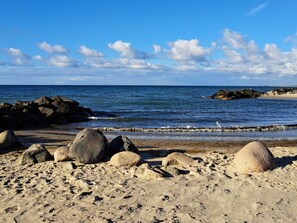 A beach with large rocks and a clear blue sky.