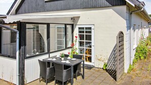 A two-story house with a balcony, a dining area with a table and chairs, and a garage. - "Gæsling" - 1.6km from the sea by Interhome (Skagen)